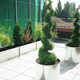 The grey paving slabs on this roof top garden are vastly improved with contemporary exterior landscping from Office Landscapes